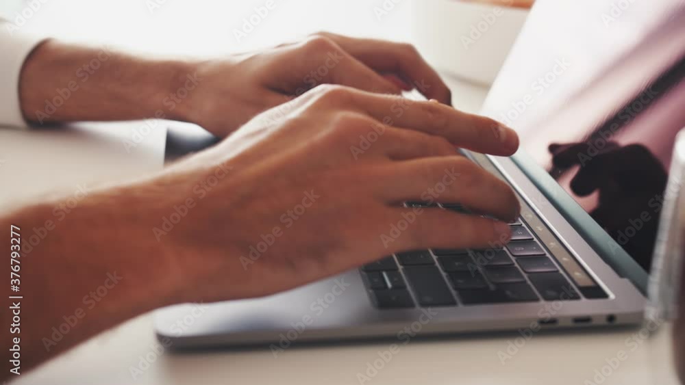 Close up shot of hands of unrecognizable businessman typing on laptop keyboard while working at home office desk Close up shot of hands of unrecognizable businessman typing on laptop keyboard while working at home office desk