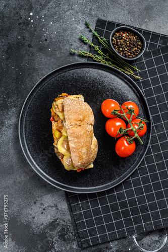 ciabatta sandwich with meatballs, cheese and tomato sauce. Black background. Top view