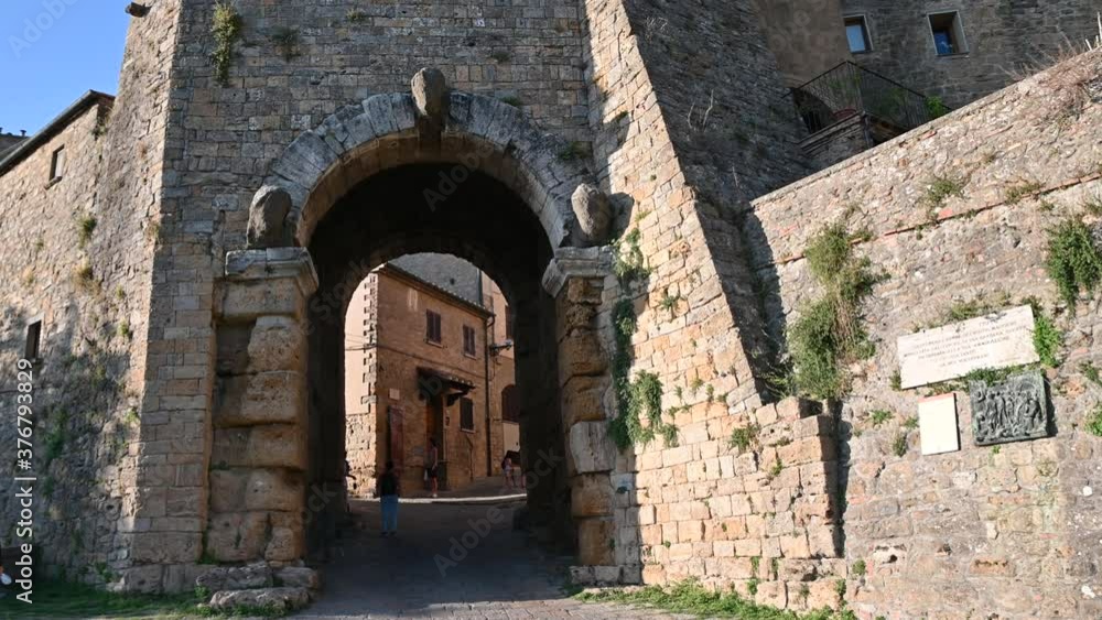 Volterra, tuscany, Italy. August 2020. One of the Etruscan access doors to the historic center. People cross the passage, some stop to observe it. Volterra, tuscany, Italy. August 2020. One of the Etruscan access doors to the historic center. People cross the passage, some stop to observe it.