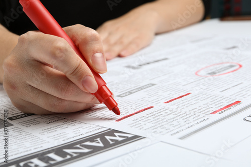Woman marking advertisement in newspaper, closeup. Job search concept