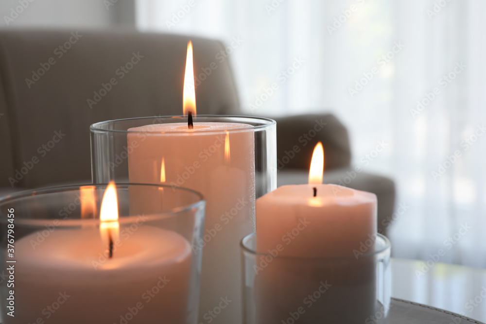 Burning candles in glass holders indoors, closeup Burning candles in glass holders indoors, closeup