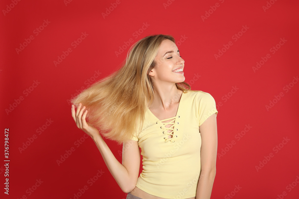 Portrait of beautiful young woman with blonde hair on red background Portrait of beautiful young woman with blonde hair on red background