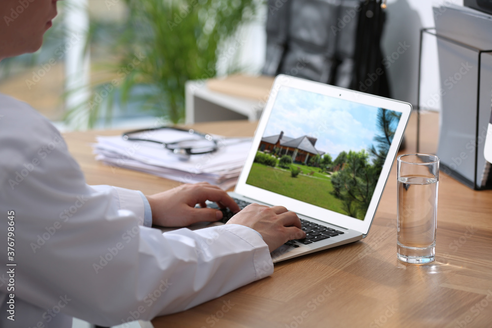Real estate agency online service. Doctor choosing new house via laptop, closeup Real estate agency online service. Doctor choosing new house via laptop, closeup