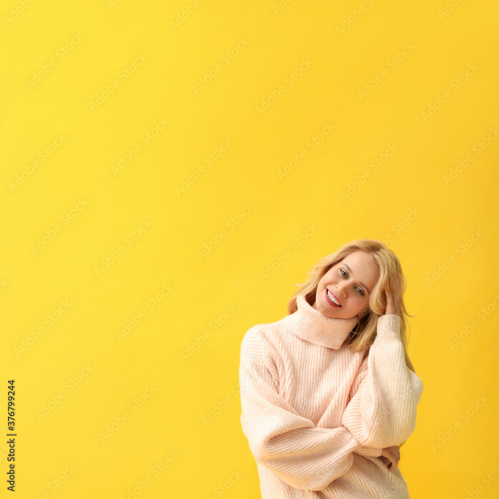 Beautiful young woman wearing warm pink sweater on yellow background. Space for text Beautiful young woman wearing warm pink sweater on yellow background. Space for text
