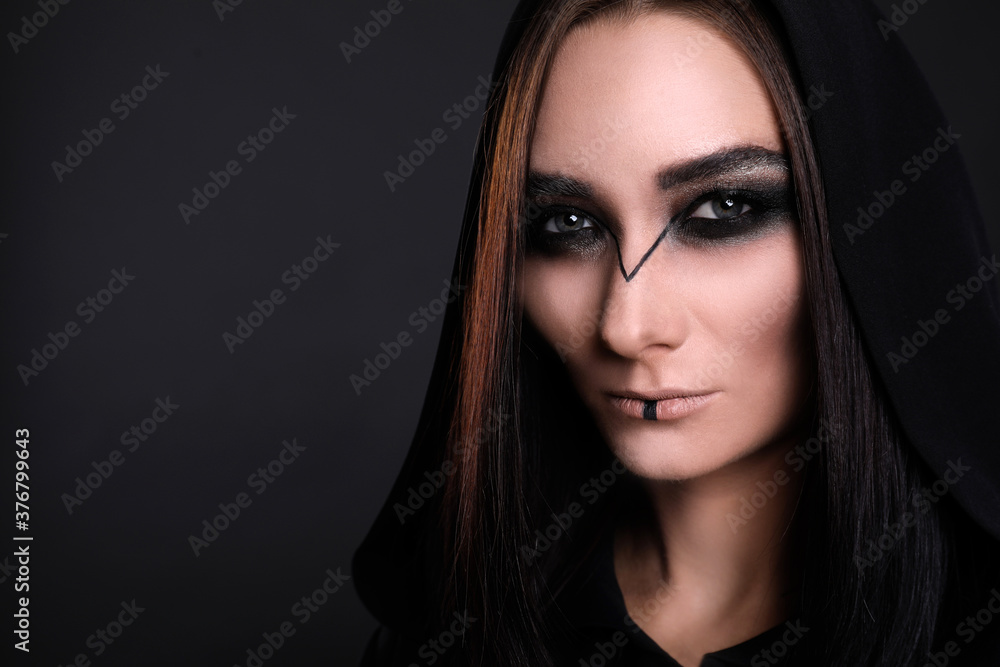 Mysterious witch in mantle with hood on black background, closeup. Space for text Mysterious witch in mantle with hood on black background, closeup. Space for text
