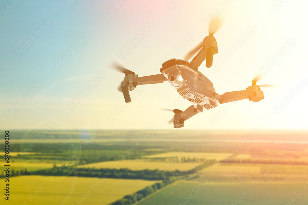 Modern drone flying over fields on sunny day. Aerial survey Modern drone flying over fields on sunny day. Aerial survey