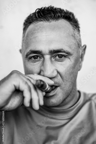 man smokes a cigar. close-up portrait