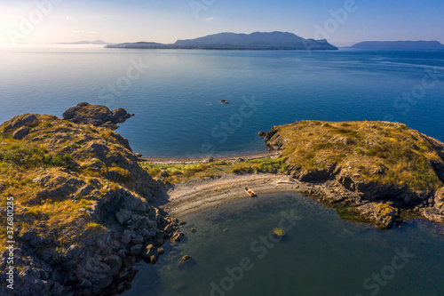 Boating in the San Juan Islands Of Puget Sound and Washington State. Aerial view of a small skiff on the beach at Lummi Rocks off the southwest corner Of Lummi Island in the Pacific Northwest.