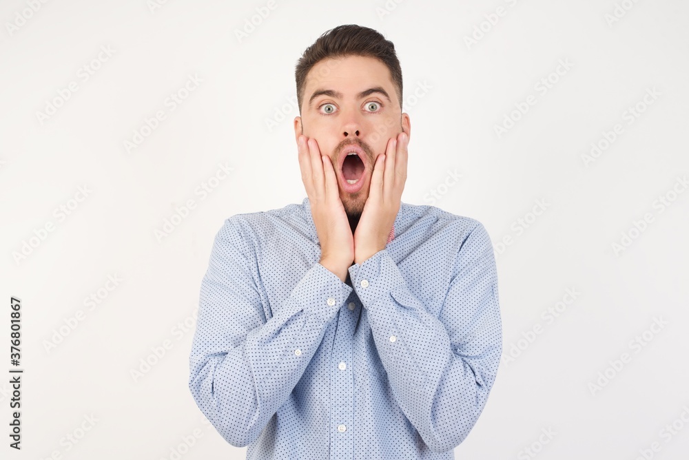Studio shot of scared terrified European man dressed in formal shirt and bow tie poses against white backgroundshocked with prices at shop, being short of money to buy something, Studio shot of scared terrified European man dressed in formal shirt and bow tie poses against white backgroundshocked with prices at shop, being short of money to buy something,