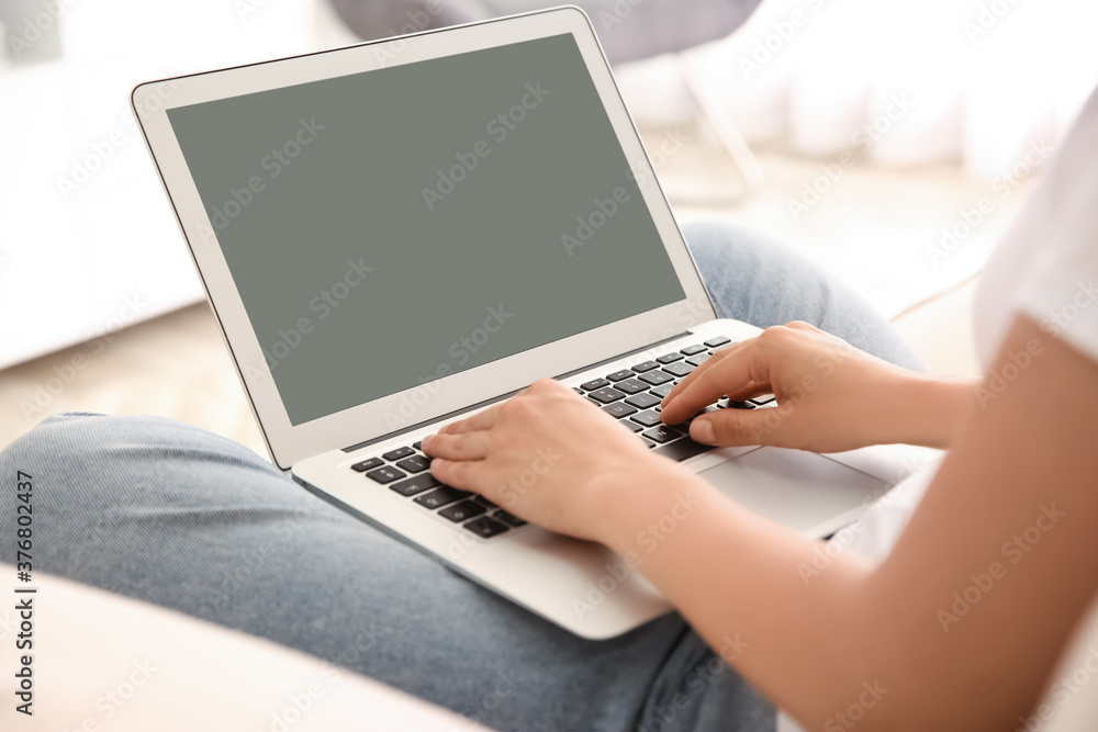 Fototapeta premium Woman working with modern laptop indoors, closeup. Space for design