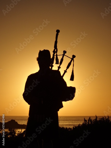 silhouette of a man playing the Bagpipes