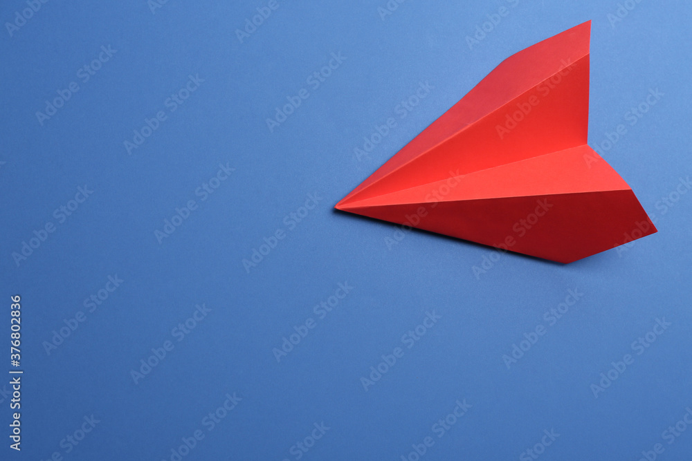 Red paper plane on blue background, top view. Space for text Red paper plane on blue background, top view. Space for text