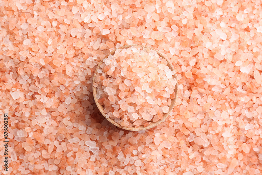 Pink himalayan salt and wooden bowl as background, top view Pink himalayan salt and wooden bowl as background, top view