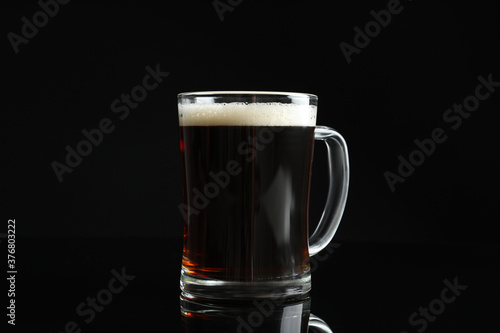 Glass mug of delicious kvass on black background