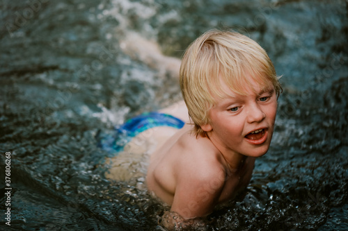 Boy swimming in natural swimming hole in central New South Wales, Australia