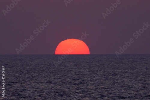 海に半分とけた夕陽 © あゆみ 柴田