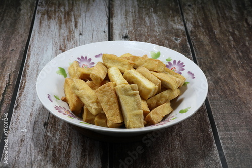 Pile of traditional deep fried cutting tofu on the plate. Famous vegetarian snack and popular ingredients in Chinese restaurant. 