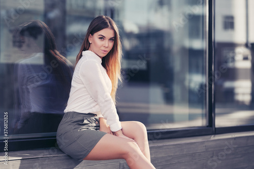 Young fashion woman in white shirt and gray mini skirt