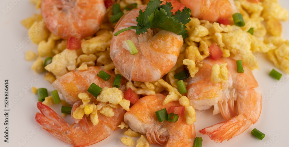 Stir fried eggs with shrimp on a white plate. Stir fried eggs with shrimp on a white plate.