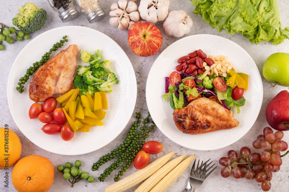 Chicken steak topped with white sesame, peas, tomatoes, broccoli and pumpkin in a white plate. Chicken steak topped with white sesame, peas, tomatoes, broccoli and pumpkin in a white plate.