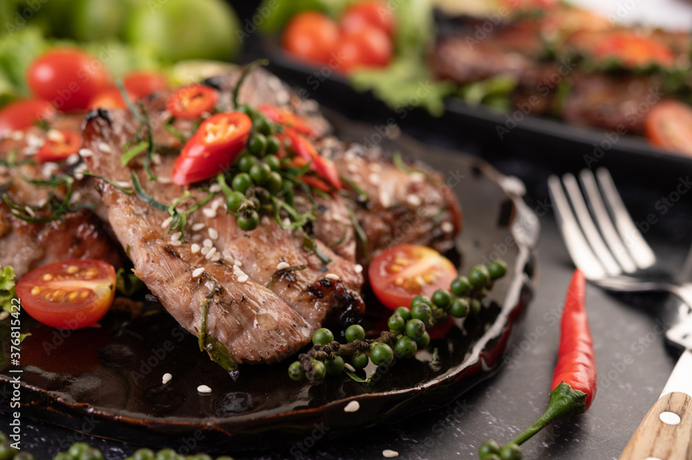 Sliced ​​pork steak topped with white sesame and fresh pepper seeds along.