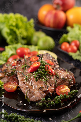 Sliced ​​pork steak topped with white sesame and fresh pepper seeds along.