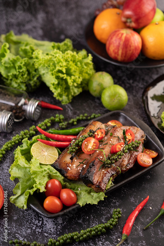 Sliced       pork steak topped with white sesame and fresh pepper seeds along.