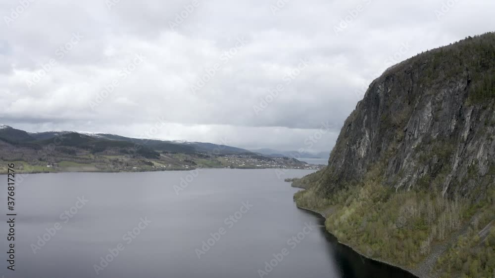 Large mountain and small Norwegian town in background from drone Large mountain and small Norwegian town in background from drone