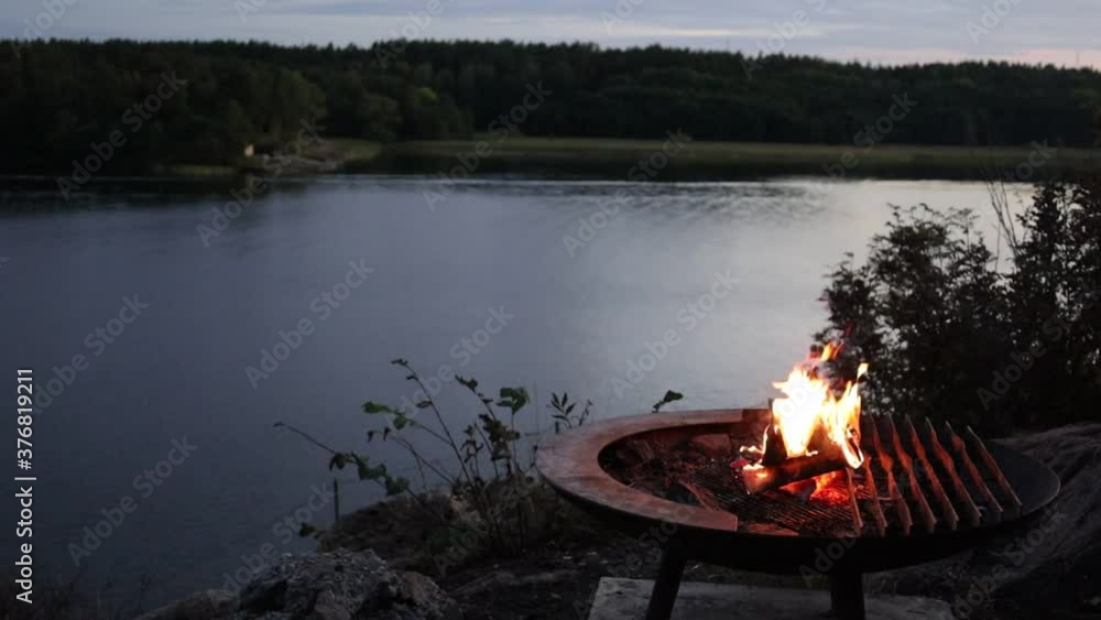 Stockholm, Sweden A campfire burns by Lake Malaren at sunset.