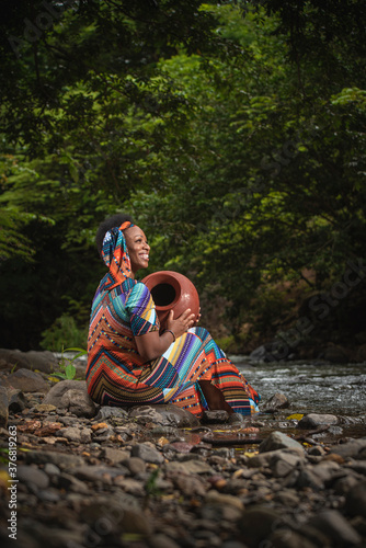 Mujer afroamericana a la orilla de una rio con vasijas  photo