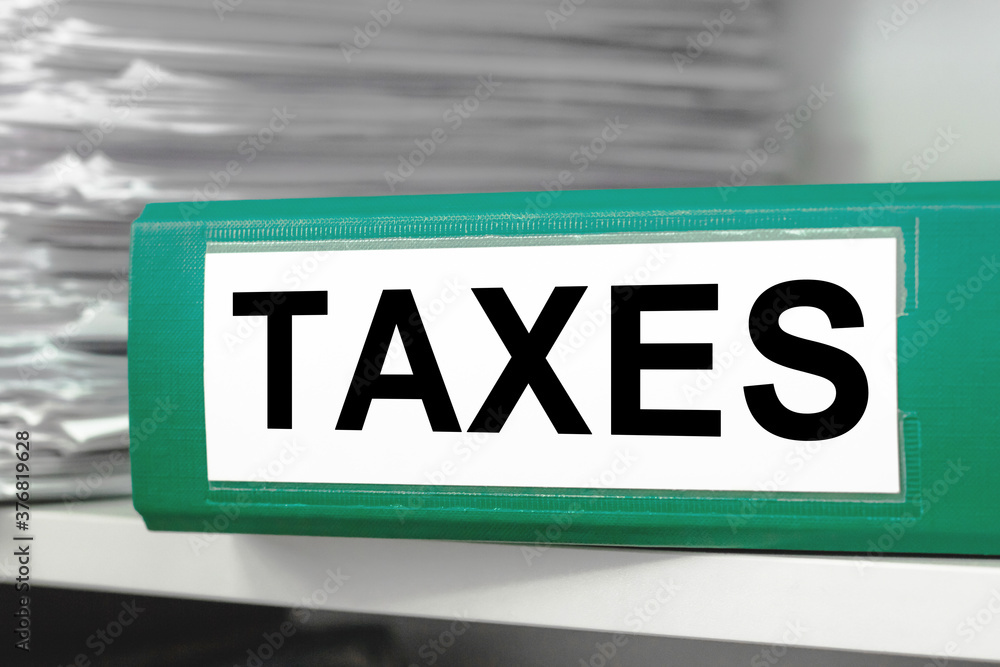 TAXES .Many papers orderly arranged in a file shelves. And some are still on the table. Business reports, work progress Analyze document plans TAXES .Many papers orderly arranged in a file shelves. And some are still on the table. Business reports, work progress Analyze document plans