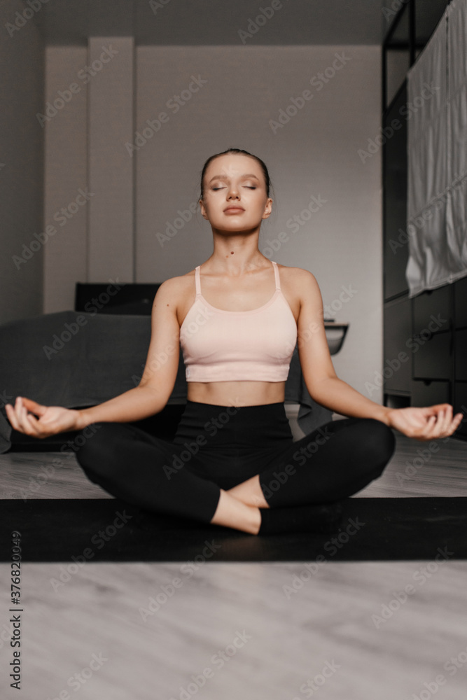 beautiful caucasian woman in sportswear practices yoga on the mat at home. Living in harmony with yourself.