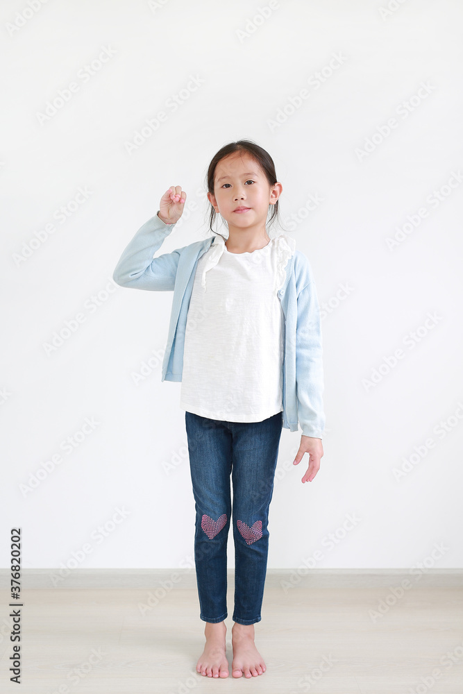 Asian little child girl expression finger pick standing in the studio room. Full-length. Asian little child girl expression finger pick standing in the studio room. Full-length.