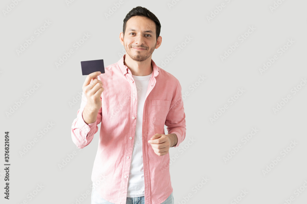 Latin man showing off his credit card Latin man showing off his credit card