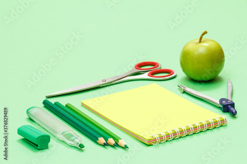 School supplies. Felt pen, color pencils, notebook, apple and scissors.