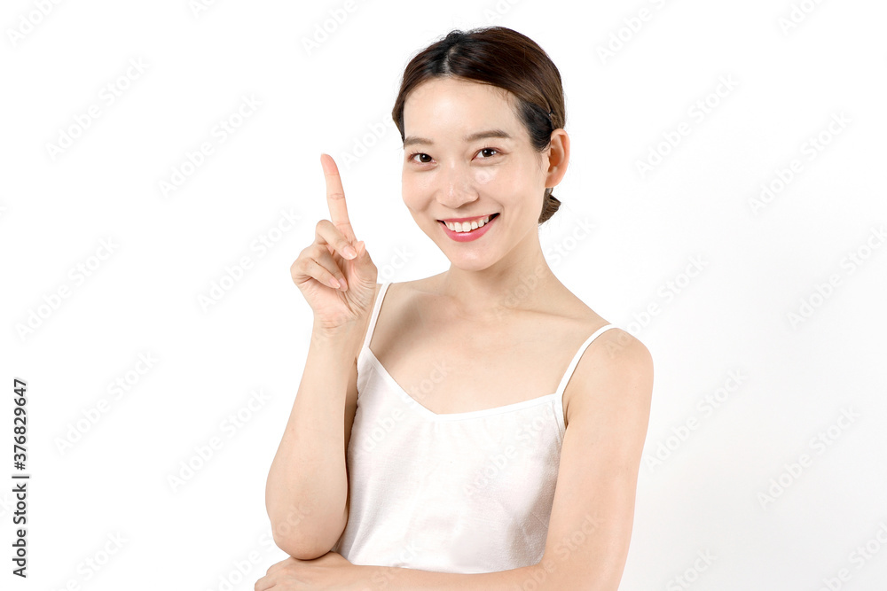 スキンケアをする女性のイメージ(人差し指を指す スキンケアをする女性のイメージ(人差し指を指す