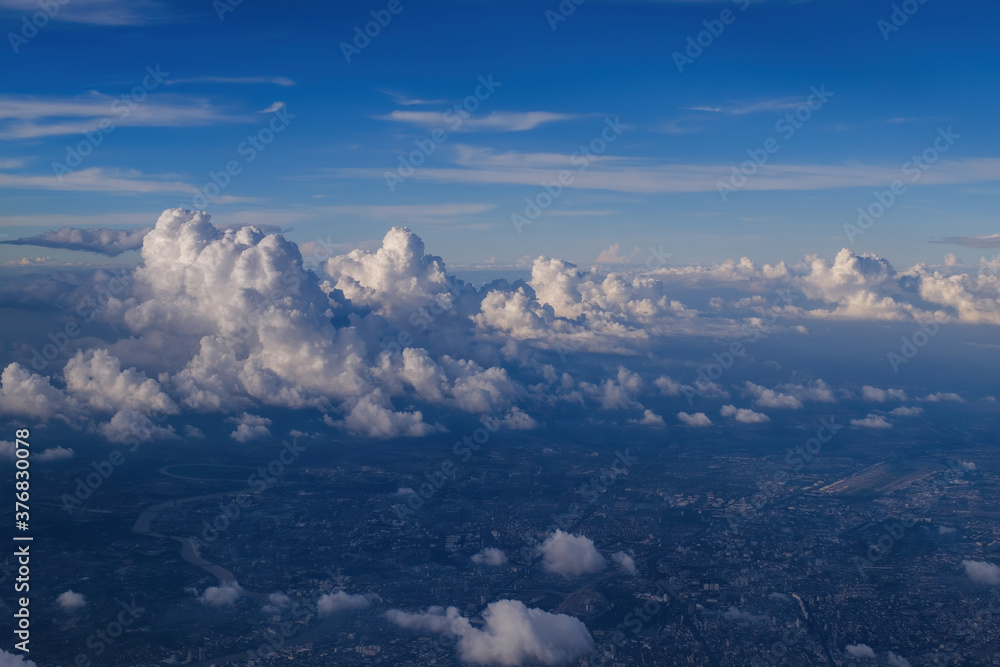 Fototapeta premium cityscape view from airplane with cloudy blue sky above, photo may has some noise