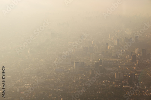 Bangkok city's bird eye view shot from a plane that flight in a morning with warming color of sunrise and some shade from clouds .photo may had some noise and partly blur