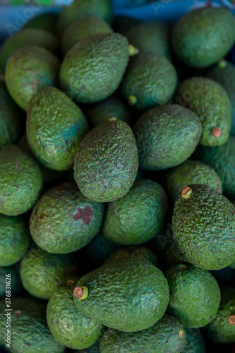 Fresh avocados at local market. Pile of avocado are selling in the fresh market. Green avocado piles of fruit sold on the streets of Thailand.