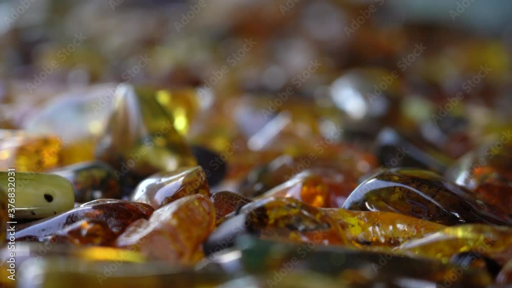 Handheld Shot with Rack Focus on Polished Scattered Pieces of Amber with Rich Orange Colour Handheld Shot with Rack Focus on Polished Scattered Pieces of Amber with Rich Orange Colour