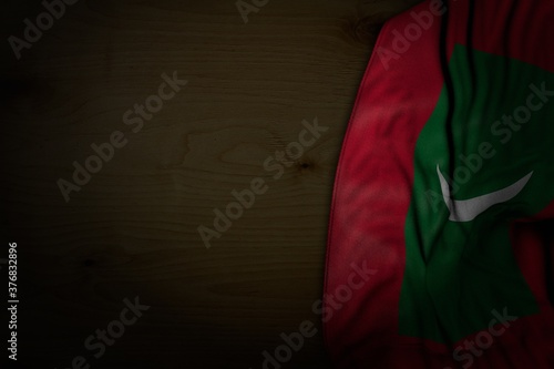 beautiful dark image of Maldives flag with big folds on dark wood with empty place for your content - any holiday flag 3d illustration..