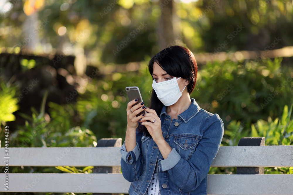 Business Woman working outside in a park wearing a mask, social distancing during a pandemic Business Woman working outside in a park wearing a mask, social distancing during a pandemic