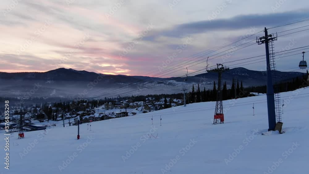 contemporary poma lift transports empty cabins over snowy mountain slope at popular ski resort against evening sky in winter contemporary poma lift transports empty cabins over snowy mountain slope at popular ski resort against evening sky in winter