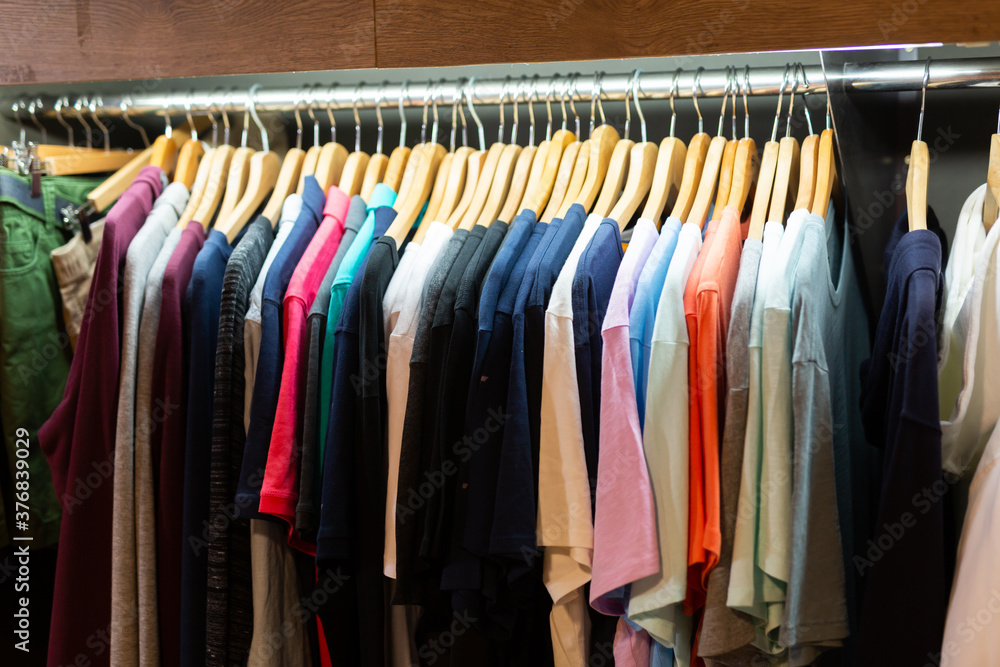 Close up view of stand with various clothes in clothing boutique