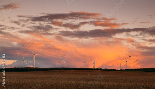 Sunset over windmills. Innovative energy creator for electric power production.