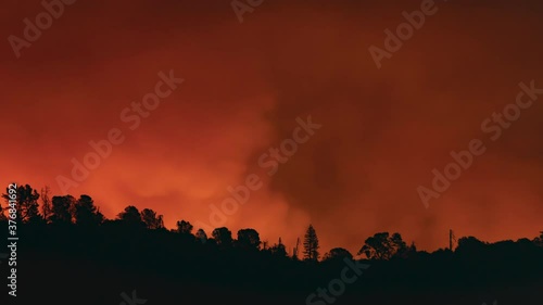 A wildfire rages beyond a ridge in southern California overnight, creating its own unique weather. photo