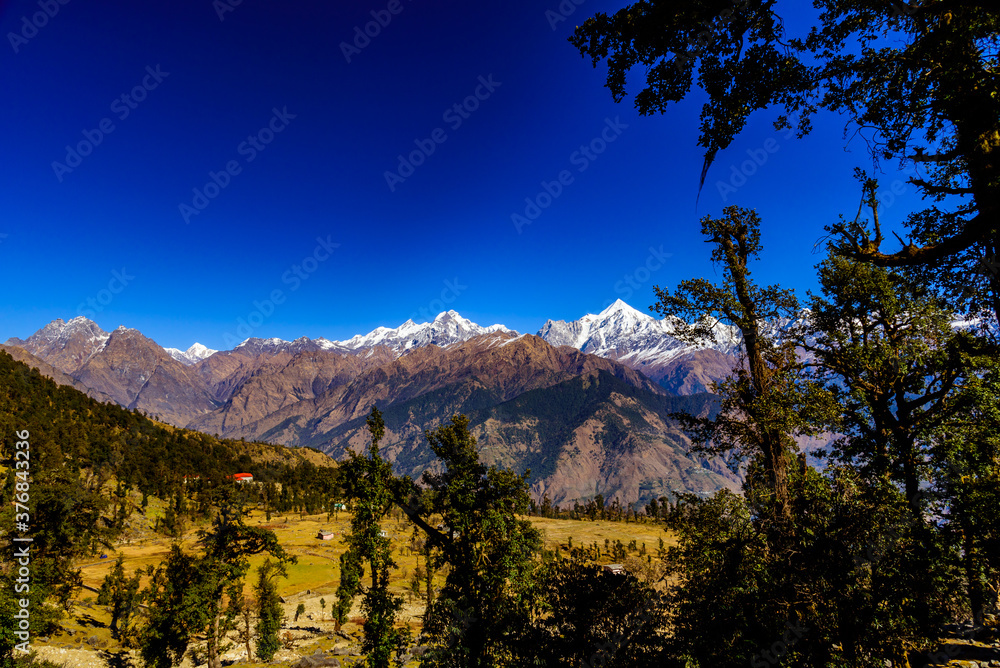 Mesmerizing view of Snow cladded Panchchuli peaks falls in great Himalayan mountain range and alpine grass meadows at small hamlet Munsiyari, Kumaon region, Uttarakhand, India.