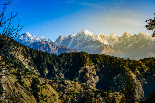 View of Snow cladded Panchchuli peaks falls in great Himalayan mountain range  & alpine grass meadows enroute to Khalia Top trekk trail at small hamlet Munsiyari, Kumaon region, Uttarakhand, India. © anjali04