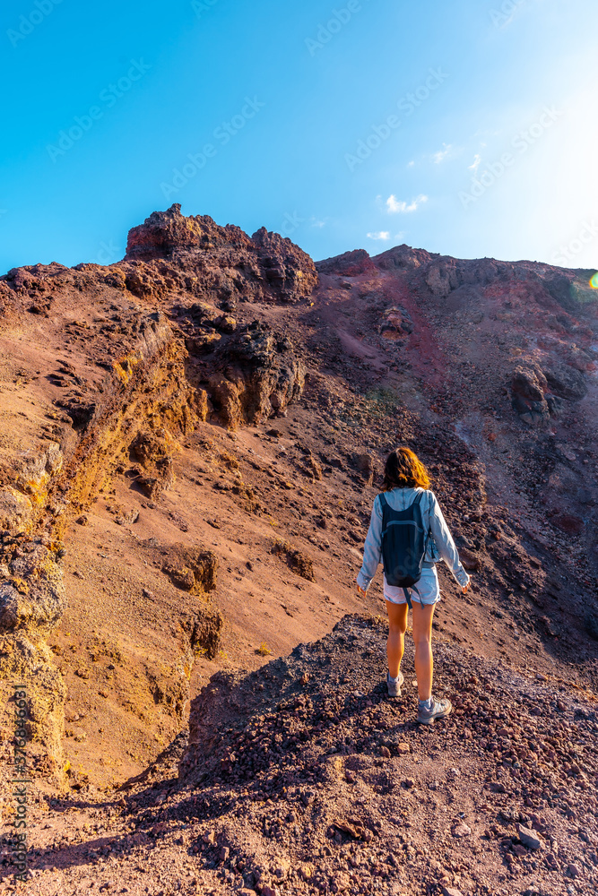 A young woman looking at the crater of the Teneguia volcano on the route of the volcanoes, La Palma island, Canary Islands. Spain