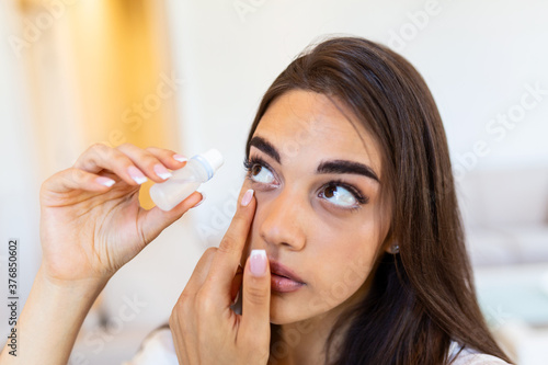 Woman using eye drop, woman dropping eye lubricant to treat dry eye or allergy; sick girl treating eyeball irritation or inflammation; sick woman suffering from irritated eye, optical symptoms